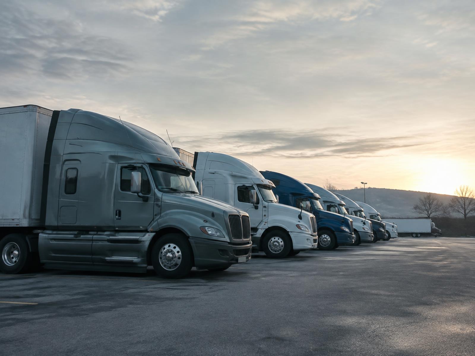Row of commercial trucks parked at a carrier yard
